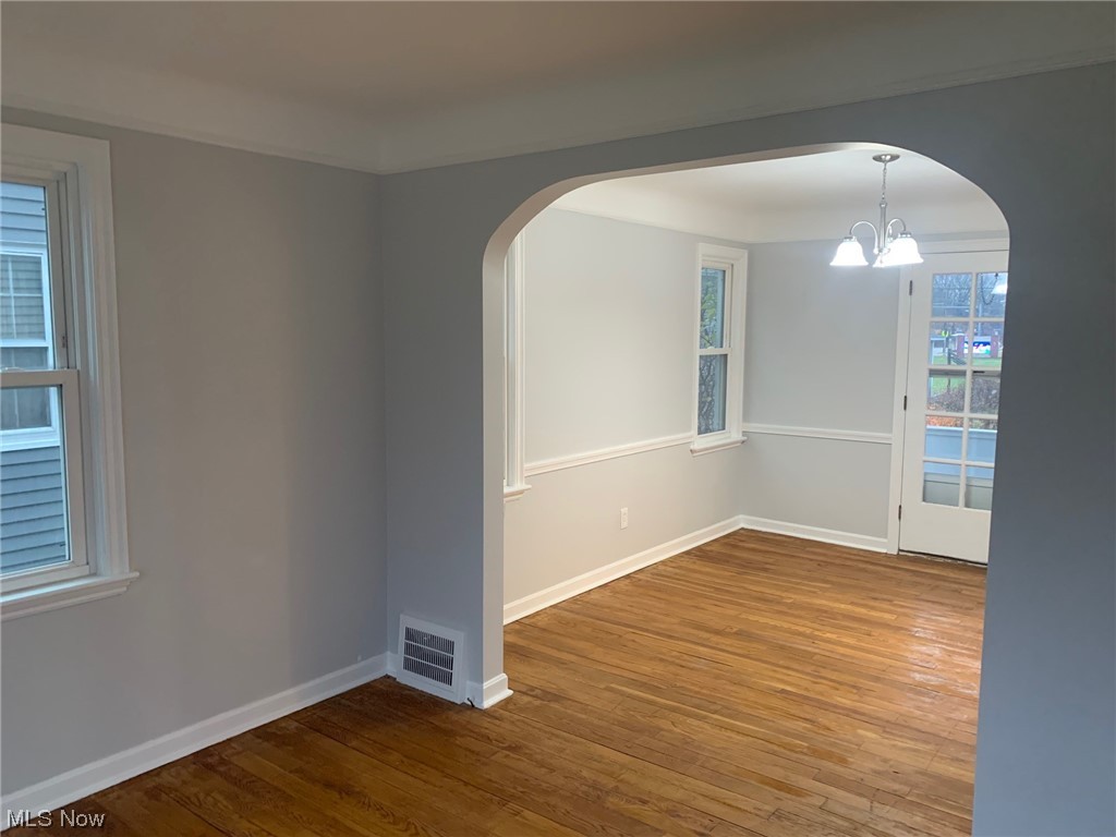 1456 Evanston Road Lyndhurst, OH 44124 - Photo 11 of 32 Empty room with an inviting chandelier and hardwood / wood-style floors