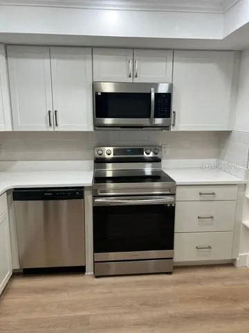 a kitchen with a refrigerator sink and cabinets