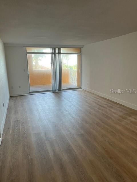 16308 Gulf Boulevard, Unit 103 Redington Beach, FL 33708 - Photo 6 of 23 an empty room with wooden floor and windows