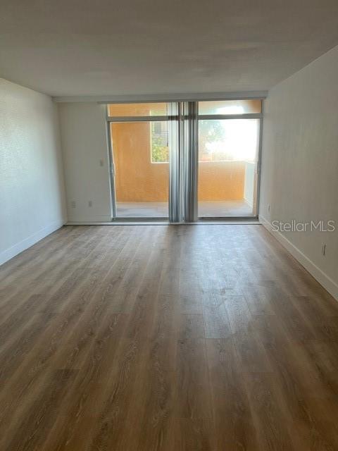 16308 Gulf Boulevard, Unit 103 Redington Beach, FL 33708 - Photo 7 of 23 an empty room with wooden floor and windows