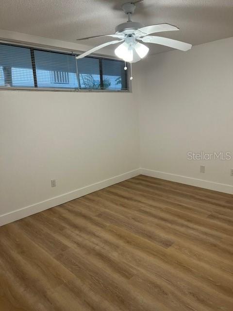 16308 Gulf Boulevard, Unit 103 Redington Beach, FL 33708 - Photo 8 of 23 a view of a room with wooden floor and chandelier fan