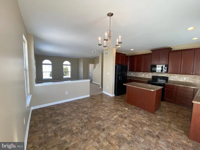a kitchen with stainless steel appliances kitchen island granite countertop a refrigerator a stove a sink dishwasher with a dining table and chairs