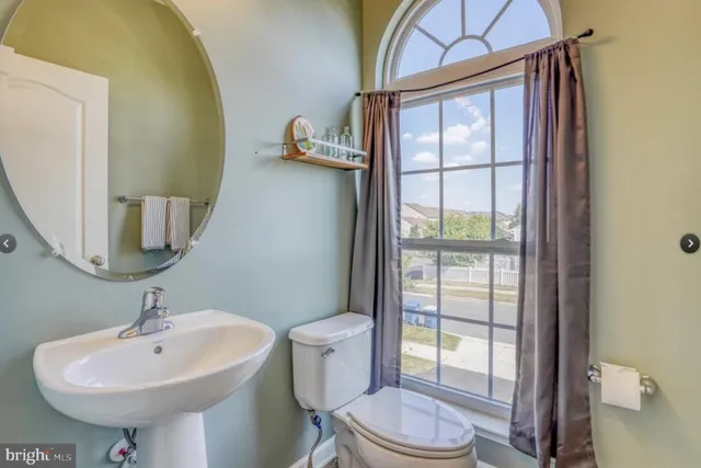 a bathroom with a sink a toilet and mirror