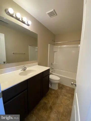 a bathroom with a double vanity sink toilet and a mirror