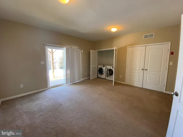a view of empty room with closet and en suite bathroom
