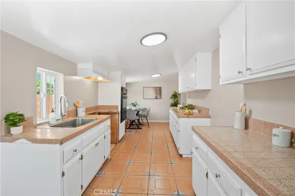 a large white kitchen with a lot of counter space and a sink