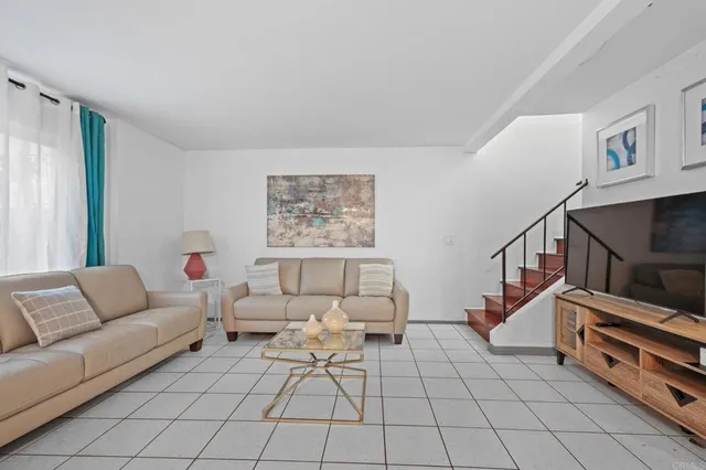 a living room with furniture and a painting on the wall