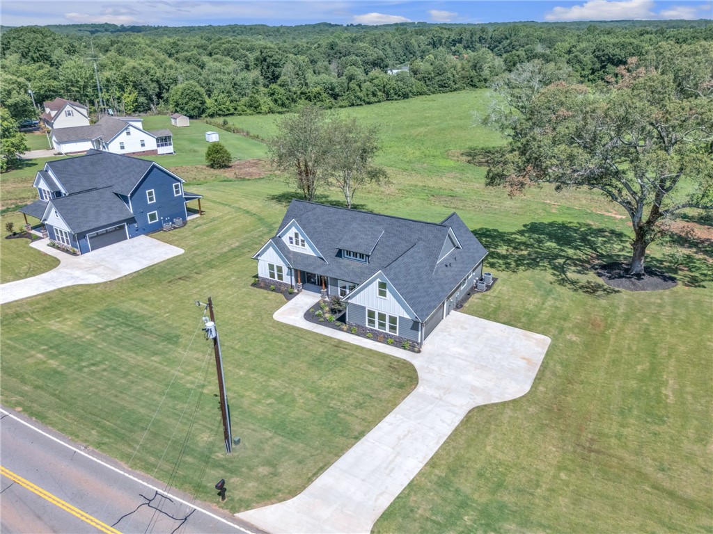 1725 Harris Bridge Road Anderson, SC 29621 - Photo 29 of 33 A striking modern farmhouse sits on a verdant lot with a spacious driveway.