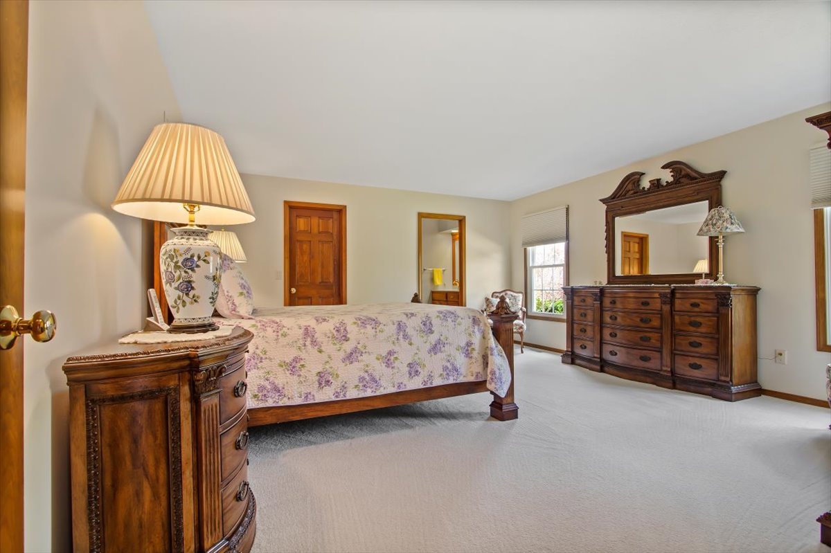 22 Barley Circle Bloomington, IL 61704 - Photo 16 of 30 a bedroom with a bed and a chandelier