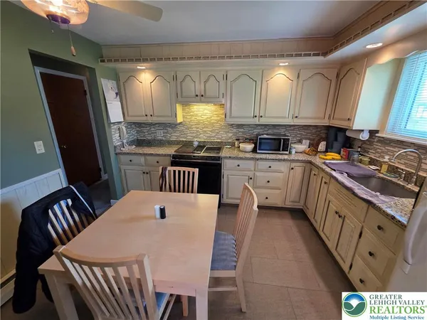 a kitchen with granite countertop a sink stove and cabinets