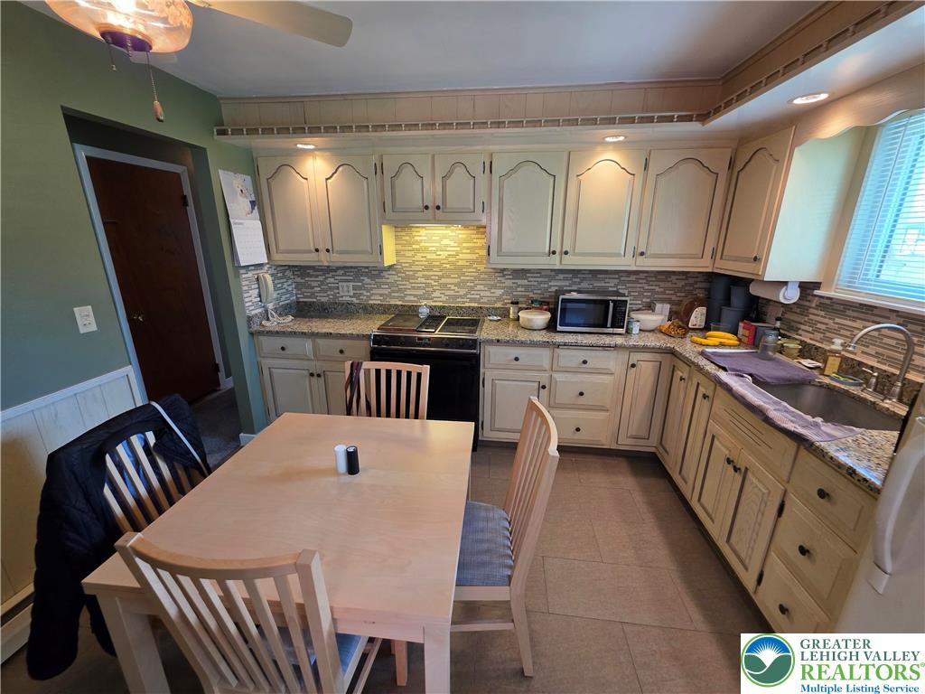 327 Sumner Avenue Whitehall, PA 18052 - Photo 23 of 38 a kitchen with granite countertop a sink stove and cabinets