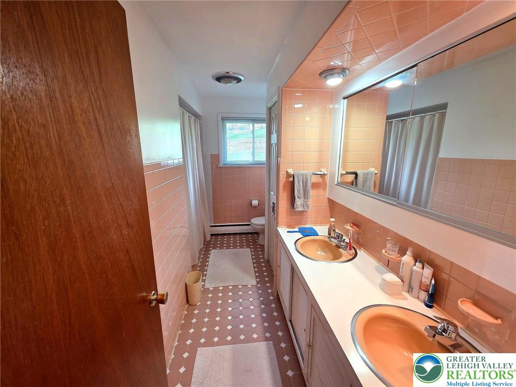 327 Sumner Avenue Whitehall, PA 18052 - Photo 24 of 38 a bathroom with a sink a mirror and a bathtub