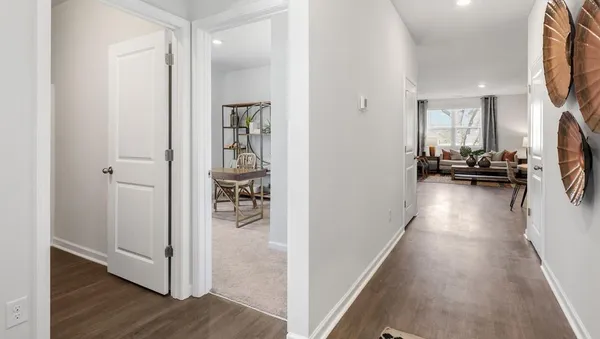 a view of a hallway with living room and wooden floor