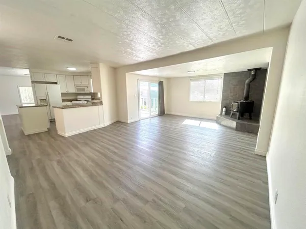a view of large kitchen with a sink and wooden floor