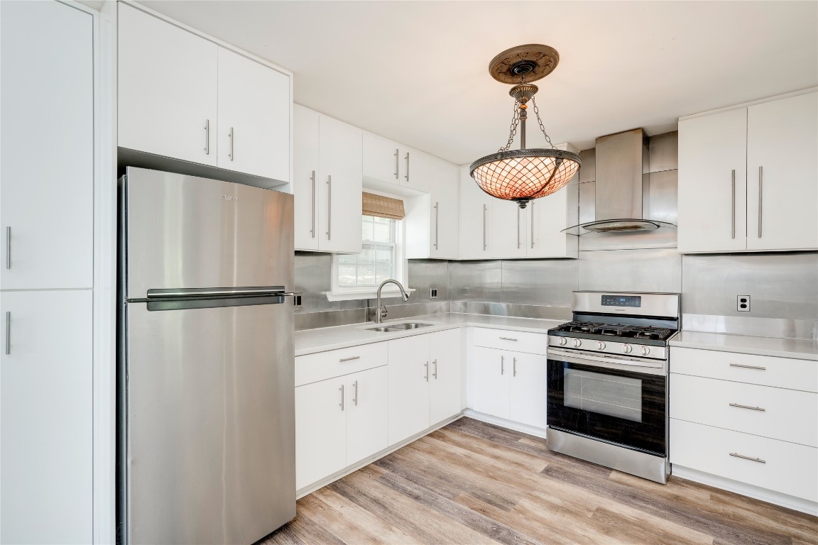 a kitchen with stainless steel appliances granite countertop a sink a stove and a refrigerator