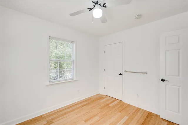 a view of a room with wooden floor and fan