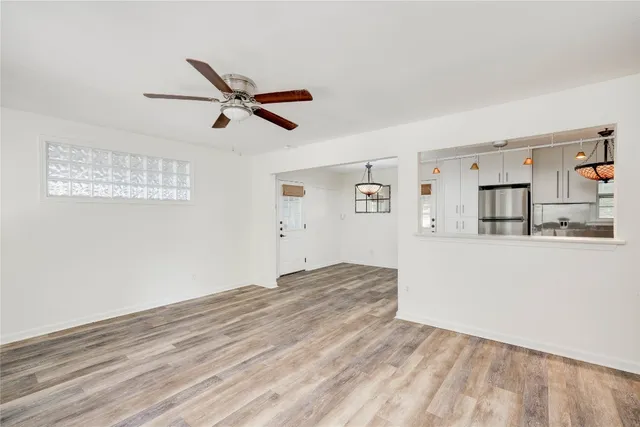 a view of a kitchen with wooden floor and a ceiling fan