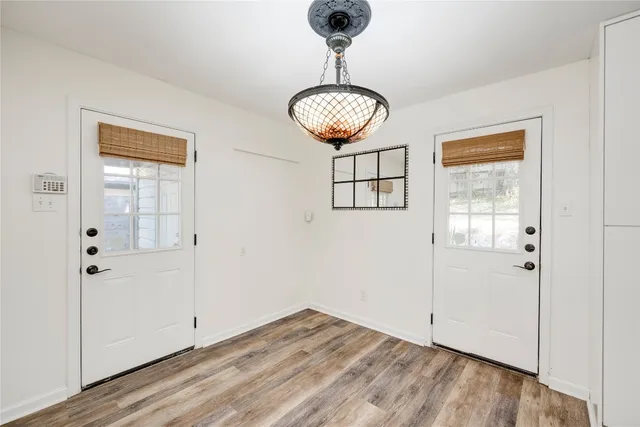 a view of a room with wooden floor and chandelier