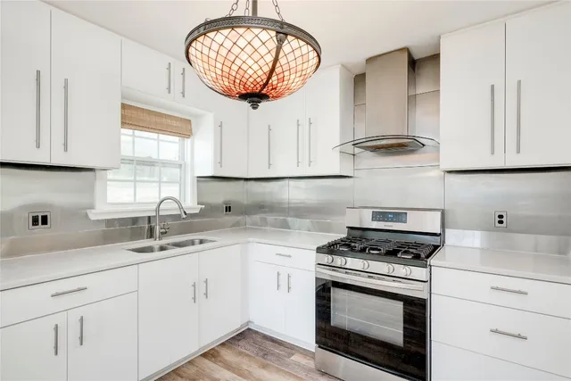 a kitchen with cabinets appliances a sink and a window