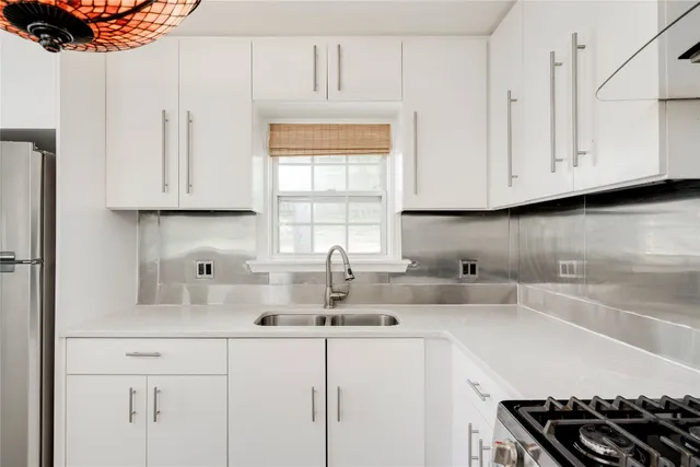 a kitchen with stainless steel appliances a sink a stove and cabinets