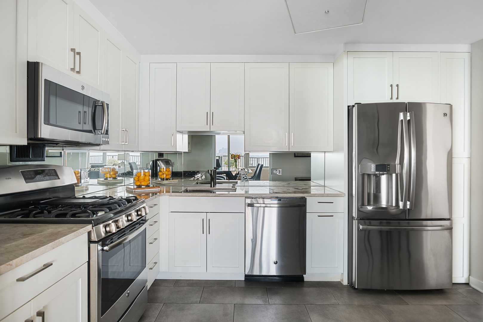 400 East Randolph Street, Unit 1403 Chicago, IL 60601 - Photo 6 of 17 a kitchen with granite countertop a refrigerator stove and microwave