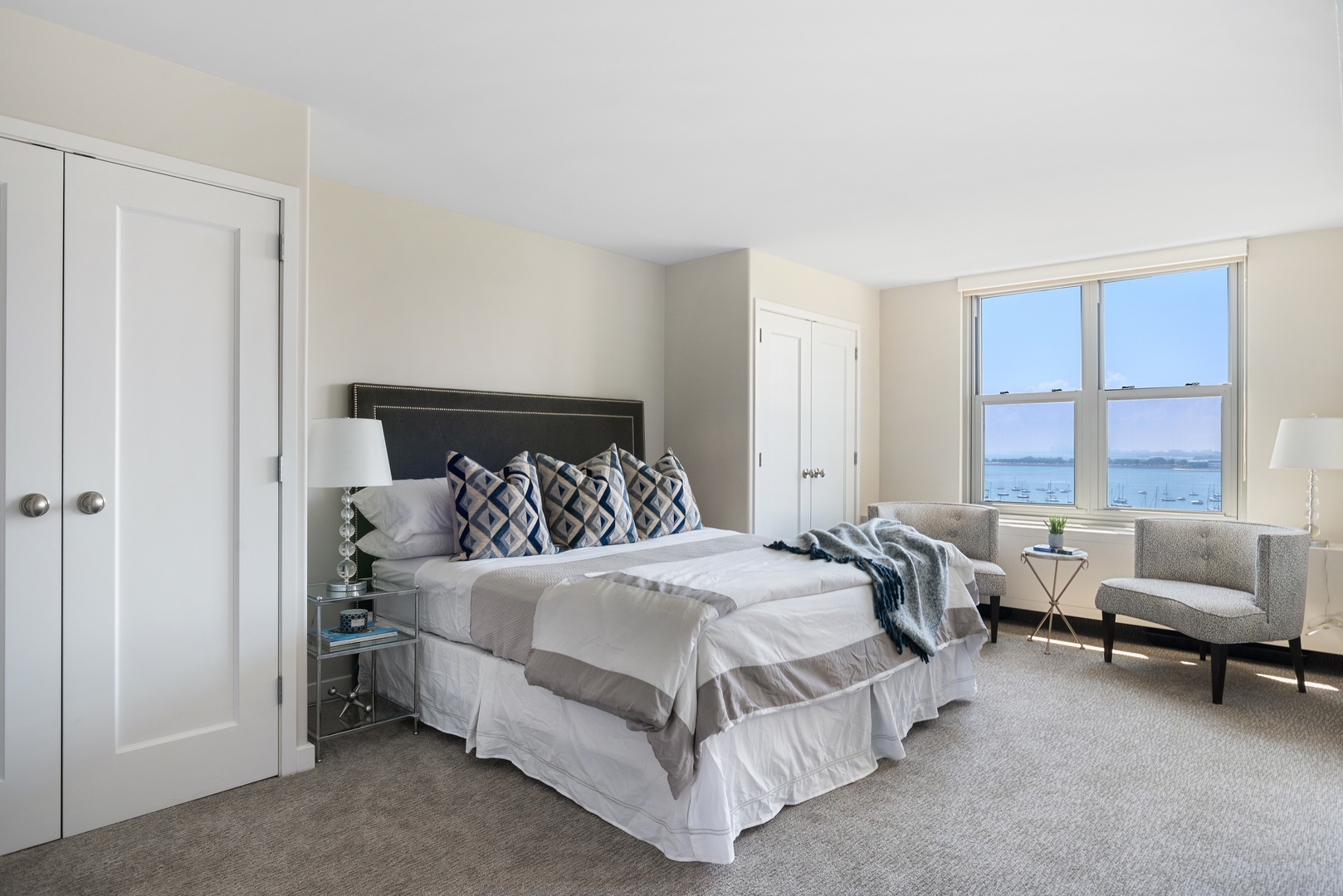 400 East Randolph Street, Unit 1403 Chicago, IL 60601 - Photo 8 of 17 a bedroom with a bed and a couch with window