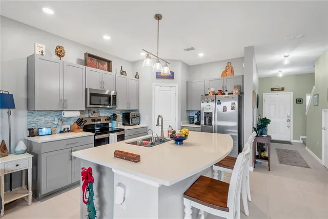 a kitchen that has a lot of cabinets a sink and appliances