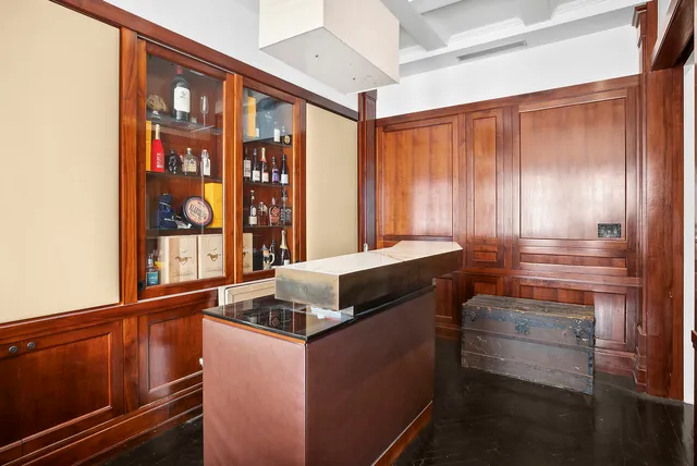 a kitchen with stainless steel appliances granite countertop a stove a refrigerator a sink a dining table and chairs with wooden floor