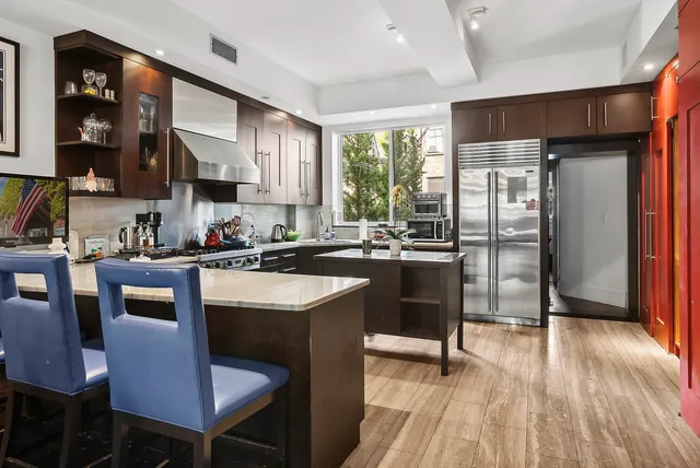 a view of a pathway with plants and large trees