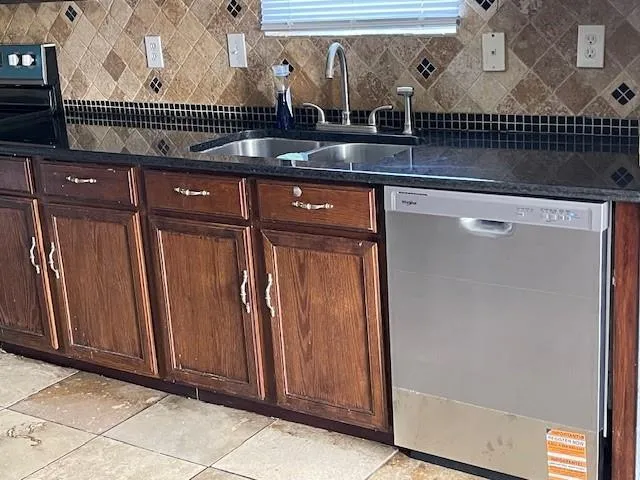 a kitchen with kitchen island granite countertop a sink stove top oven and cabinets