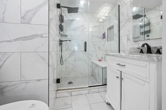 a bathroom with a shower sink mirror and toilet