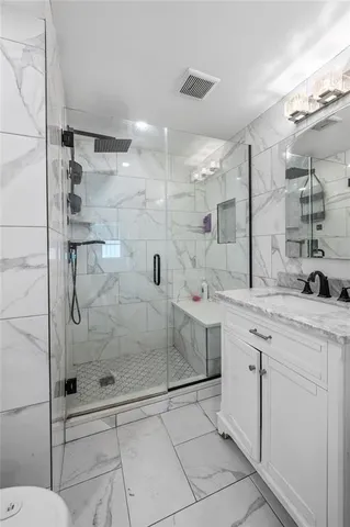 a bathroom with a shower sink and mirror