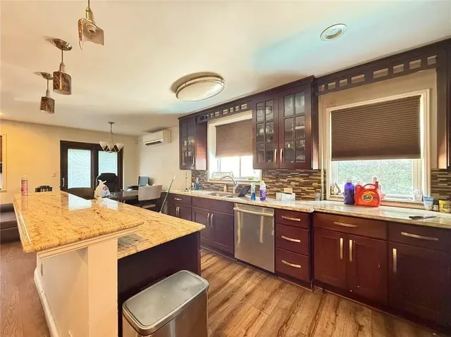 a kitchen with stainless steel appliances kitchen island granite countertop a sink stove and refrigerator