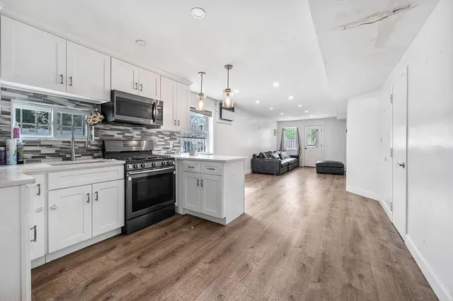 a kitchen with granite countertop a refrigerator stove top oven and sink