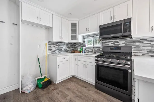 a kitchen with stainless steel appliances a stove microwave and cabinets