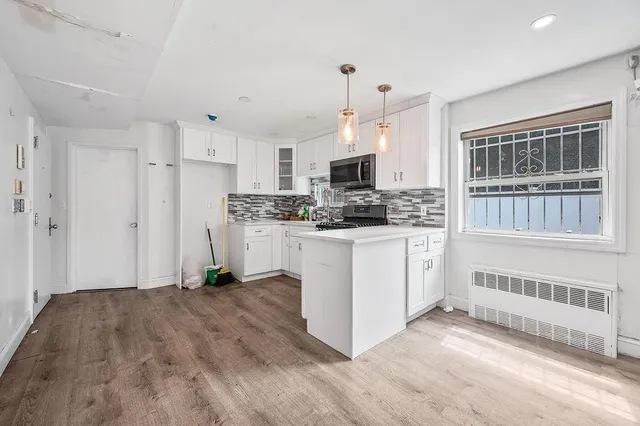 a kitchen with stainless steel appliances a white refrigerator a stove a sink and a microwave