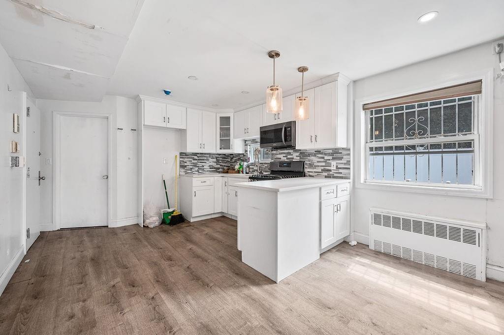 46 Rutherford Place Brooklyn, NY 11214 - Photo 7 of 20 a kitchen with stainless steel appliances a white refrigerator a stove a sink and a microwave