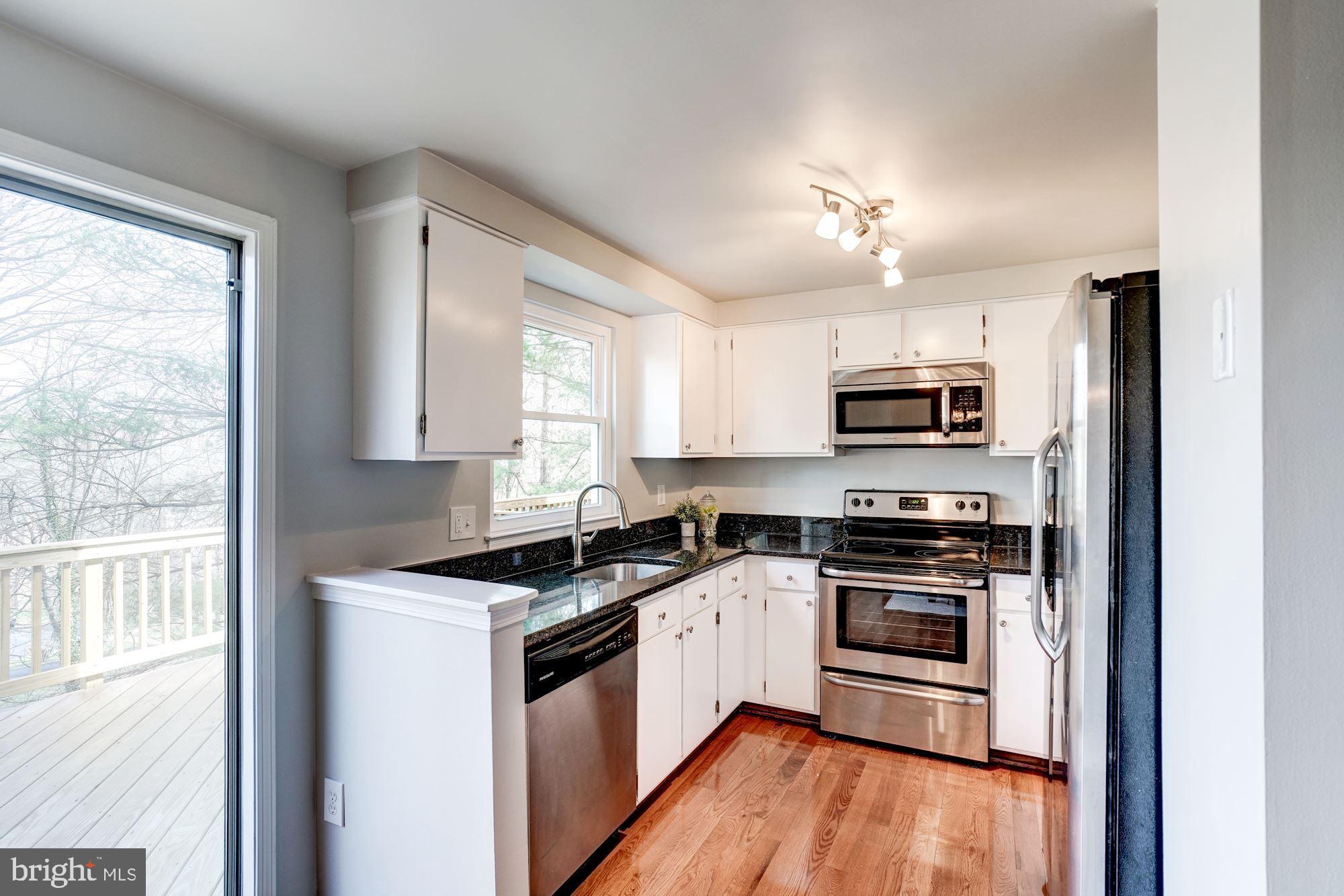 10968 Granby Court Reston, VA 20191 - Photo 9 of 33 a kitchen with stainless steel appliances granite countertop a stove a sink and a microwave