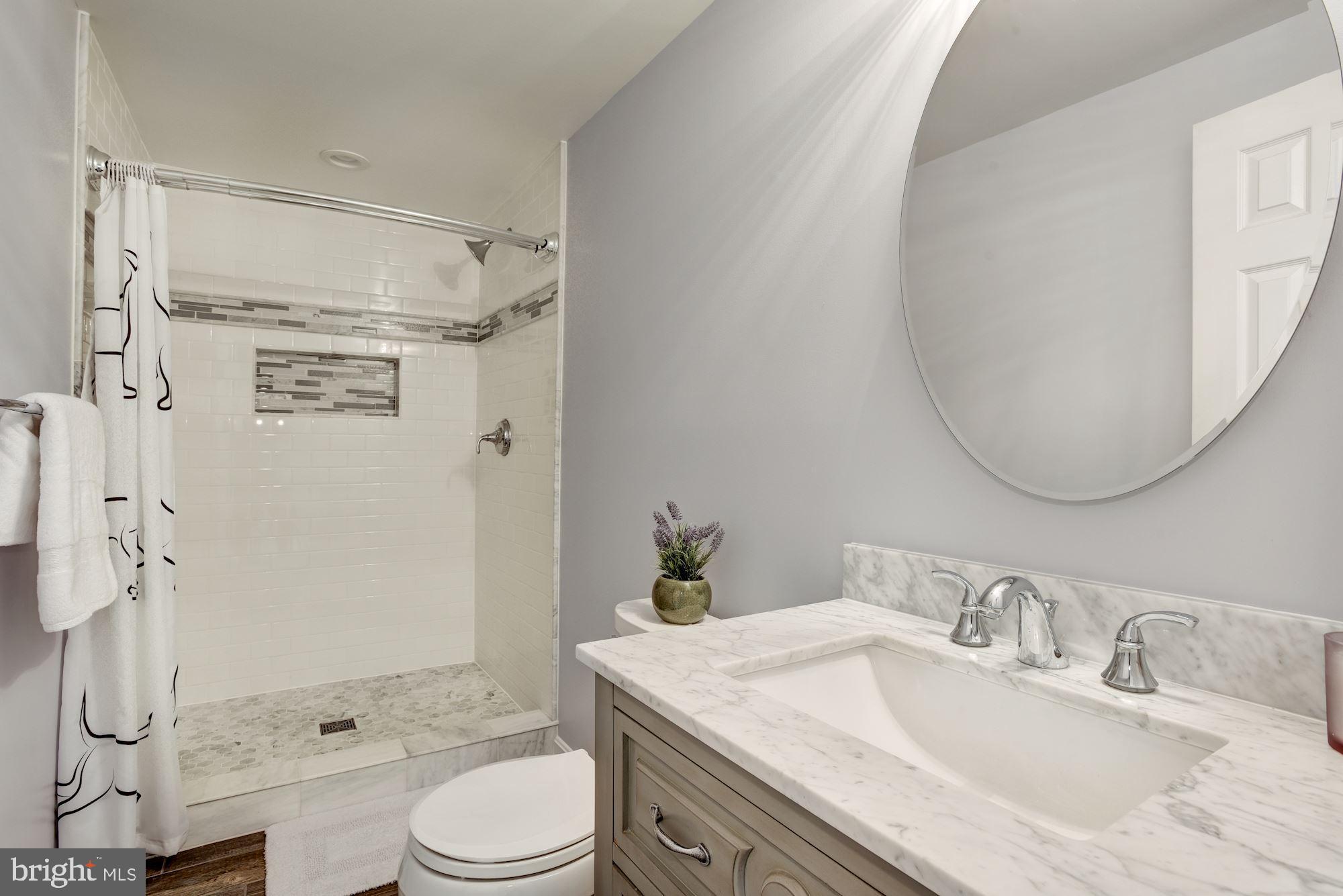 10968 Granby Court Reston, VA 20191 - Photo 28 of 33 a bathroom with a granite countertop sink toilet a mirror and shower