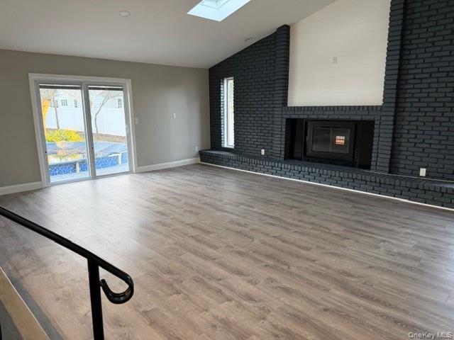 95 Muncie Road West Babylon, NY 11704 - Photo 2 of 13 a view of an empty room with wooden floor and a fireplace