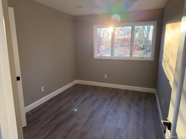 95 Muncie Road West Babylon, NY 11704 - Photo 9 of 13 an empty room with wooden floor and windows