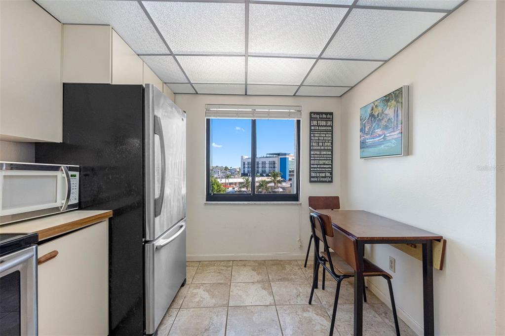 15000 Gulf Boulevard, Unit 408 Madeira Beach, FL 33708 - Photo 18 of 35 a kitchen with stainless steel appliances granite countertop a refrigerator and a stove top oven