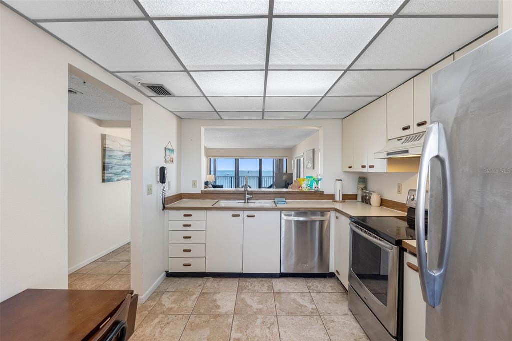 15000 Gulf Boulevard, Unit 408 Madeira Beach, FL 33708 - Photo 22 of 35 a kitchen with stainless steel appliances granite countertop a sink counter space cabinets and stainless steel appliances
