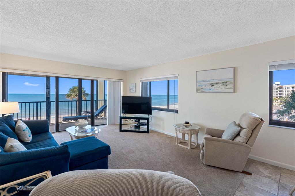 15000 Gulf Boulevard, Unit 408 Madeira Beach, FL 33708 - Photo 4 of 35 a living room with furniture a large window and a flat screen tv