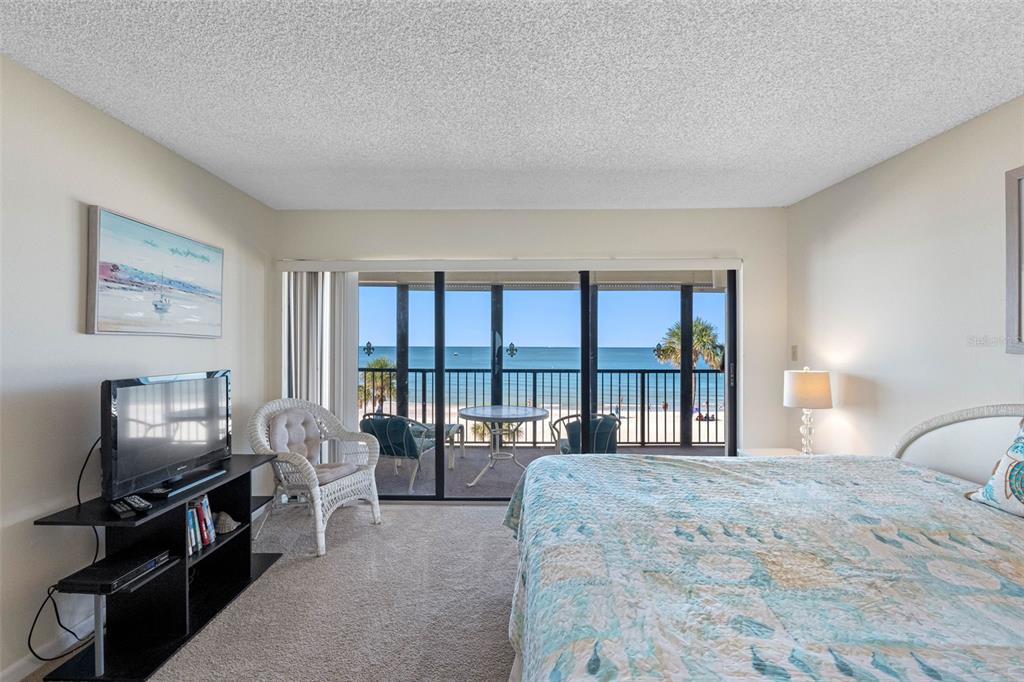 15000 Gulf Boulevard, Unit 408 Madeira Beach, FL 33708 - Photo 6 of 35 a bedroom with a bed a flat screen tv and a large window
