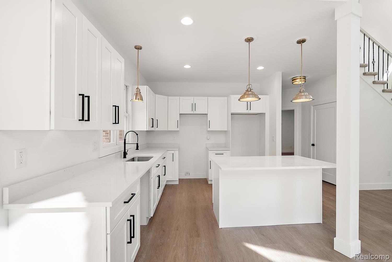 13392 Belsay Road Millington, MI 48746 - Photo 11 of 18 Contemporary kitchen featuring white shaker cabinetry, white countertops, a central island, recessed lighting, and wood-finish flooring