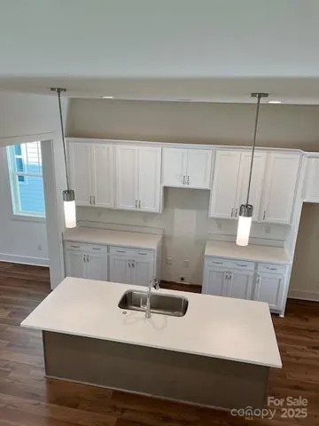 a kitchen with a sink a stove and white cabinets