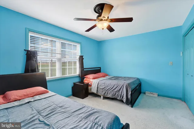 a bedroom with a bed and a large window