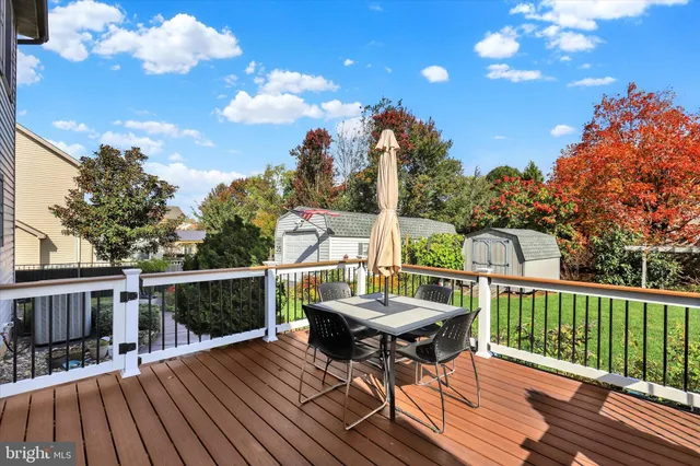 a balcony with wooden floor table and chairs