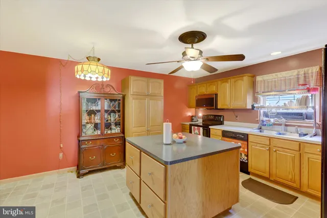 a kitchen with kitchen island stainless steel appliances a sink stove and refrigerator